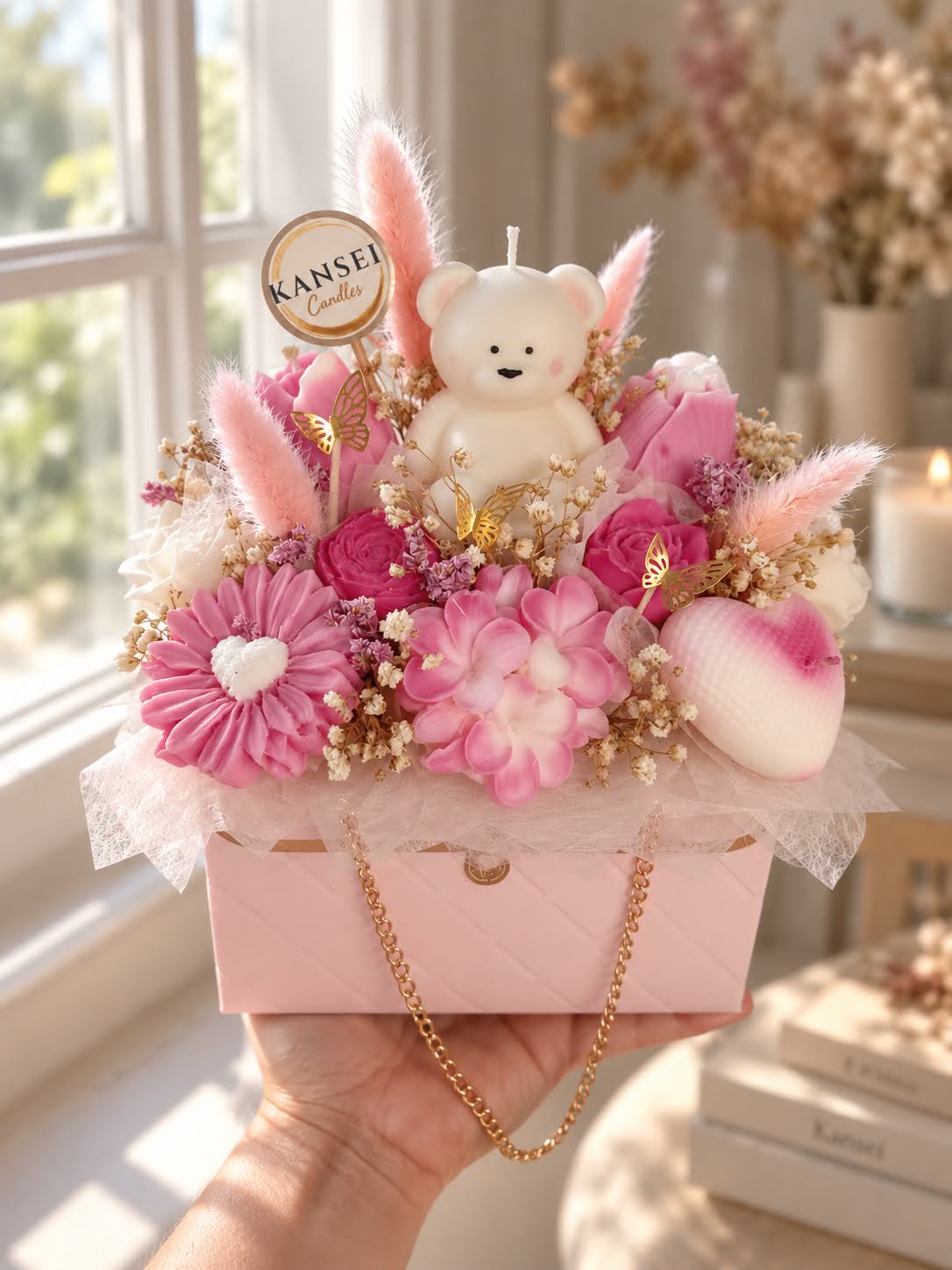 Bouquet de Autor Sakura de flores de cera rosas con vela de osito y mariposas doradas en bolso rosa