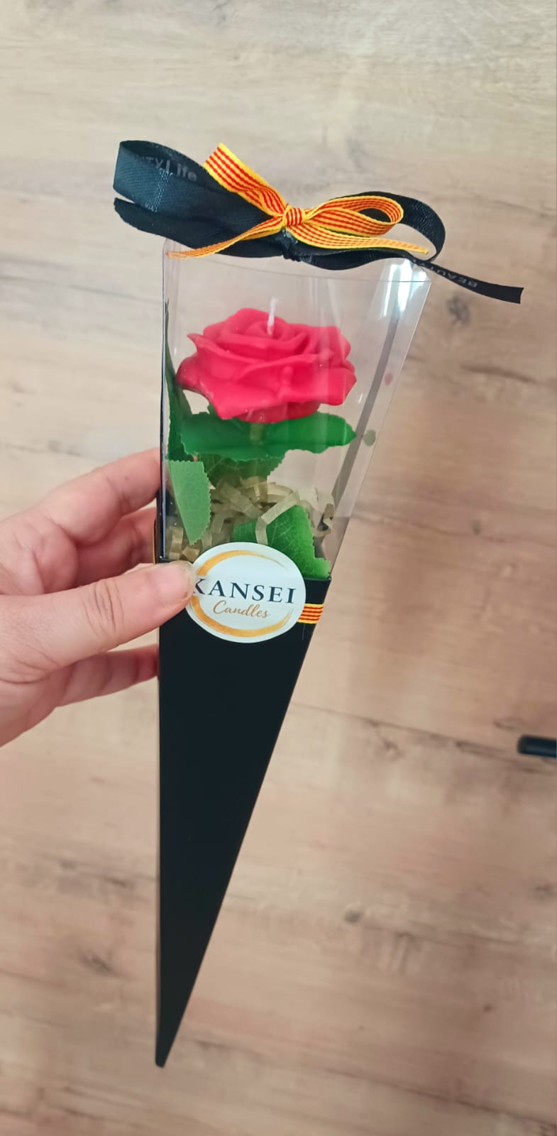 Rosa de cera roja en cono negro como detalle de invitado