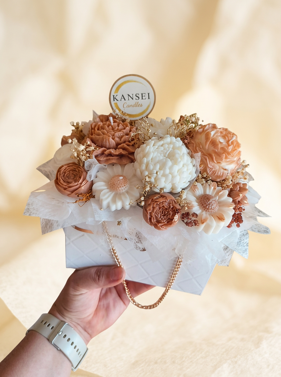Bouquet de Autor Natsukashii de flores de cera nude y marfil en bolsa blanca con cadena dorada